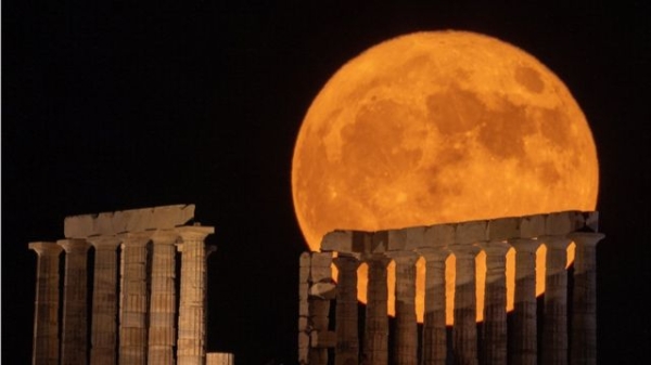 A full moon known as the "Buck Moon" rises behind the Temple of Poseidon, in Cape Sounion, near Athens, Greece