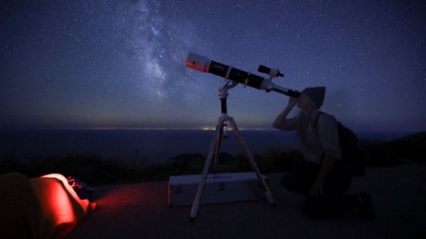 A woman looks through a telescope during the annual Perseid meteor shower on the island of Lastovo, Croatia