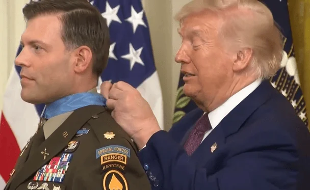 Президент Дональд Трамп надягає на шию військового Медаль Пошани / © скриншот